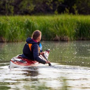 Eddyline Kayaks Sitka LT touring kayak in red. Paddler on the water in the Sitka LT. Available at authorized Eddyline dealer, Riverbound Sports in Tempe, Arizona.