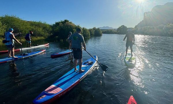 People paddleboarding on the Lower Salt River at sunrise.